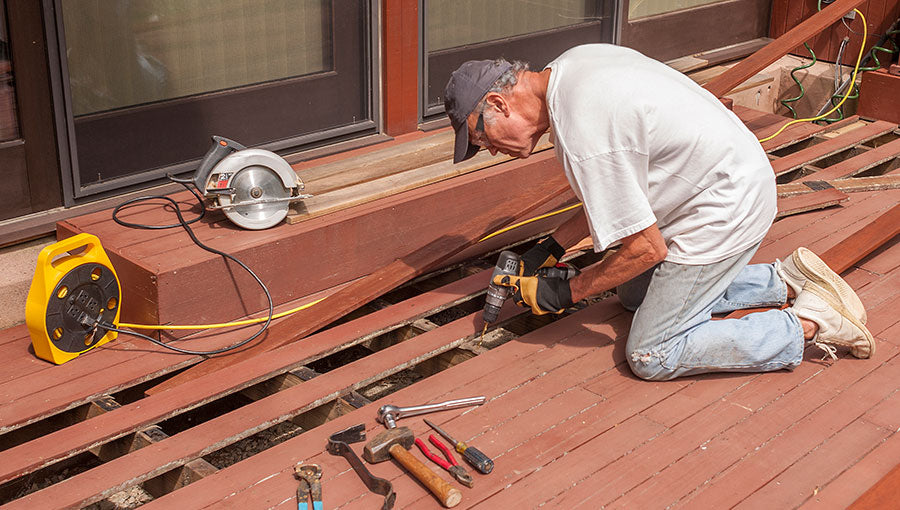 Senior repairing wood deck