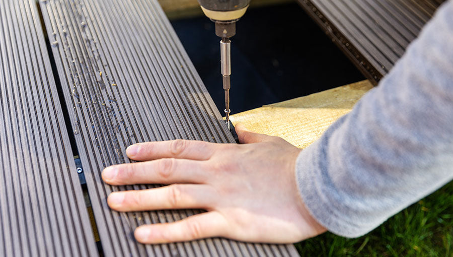 Terrace deck construction - man installing wpc composite decking boards