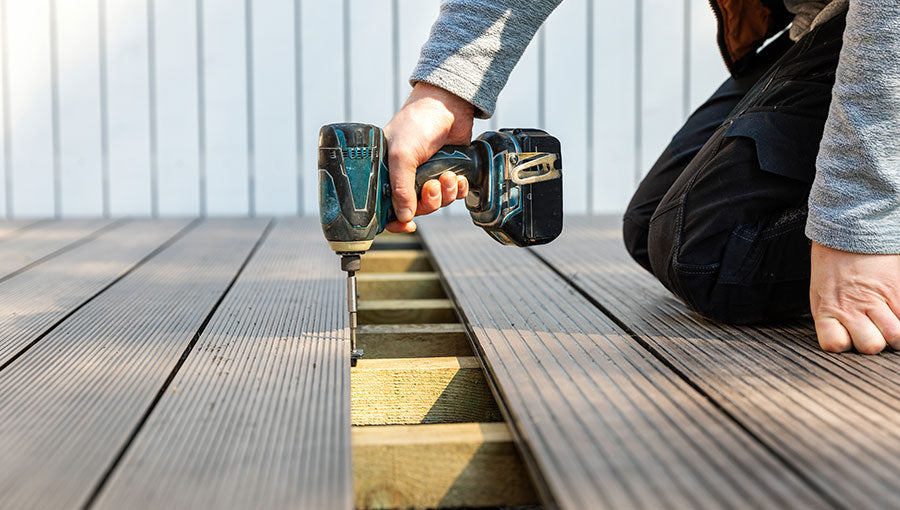 Terrace deck construction - man installing wpc composite decking boards